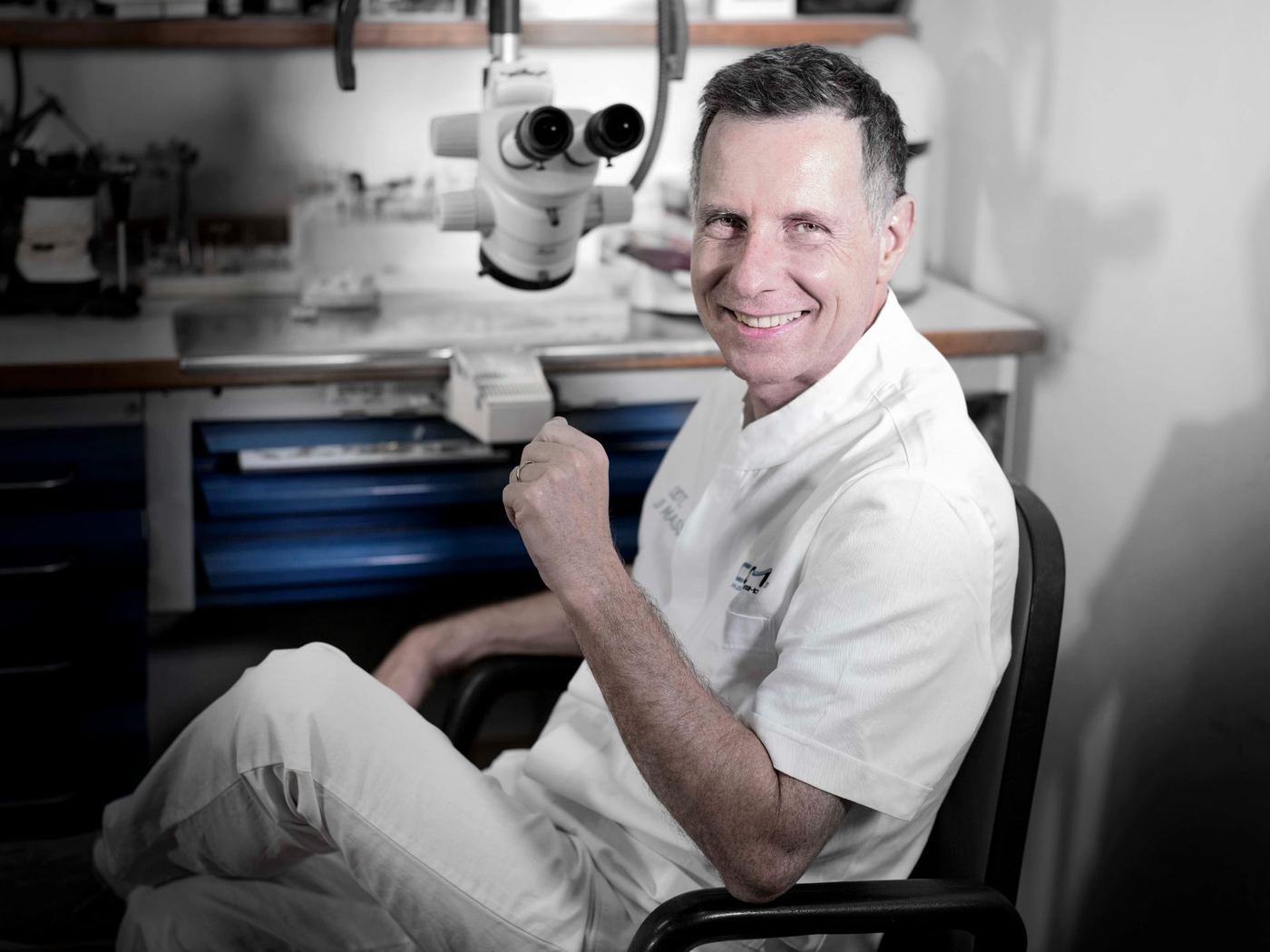 Un odontotecnico sorridente davanti al microscopio